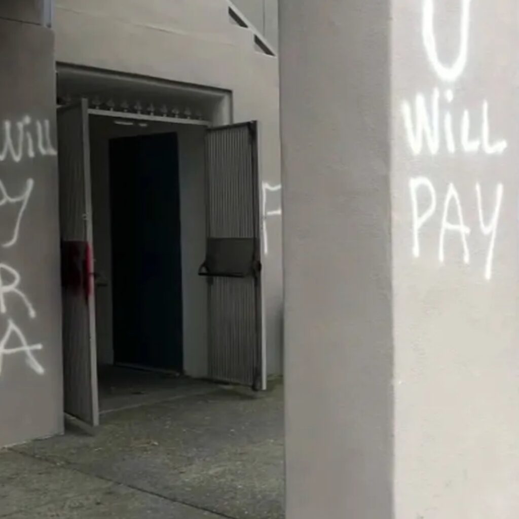 Graffiti reading 'U WILL PAY' and 'OUR LAND' is seen on the walls and pillars of the Krouzian-Zekarian-Vasbouragan (KZV) Armenian School and Community Center in San Francisco. The school was vandalized with anti-Armenian messages in July 2020. Surveillance footage captured multiple individuals defacing the building, with others acting as lookouts.