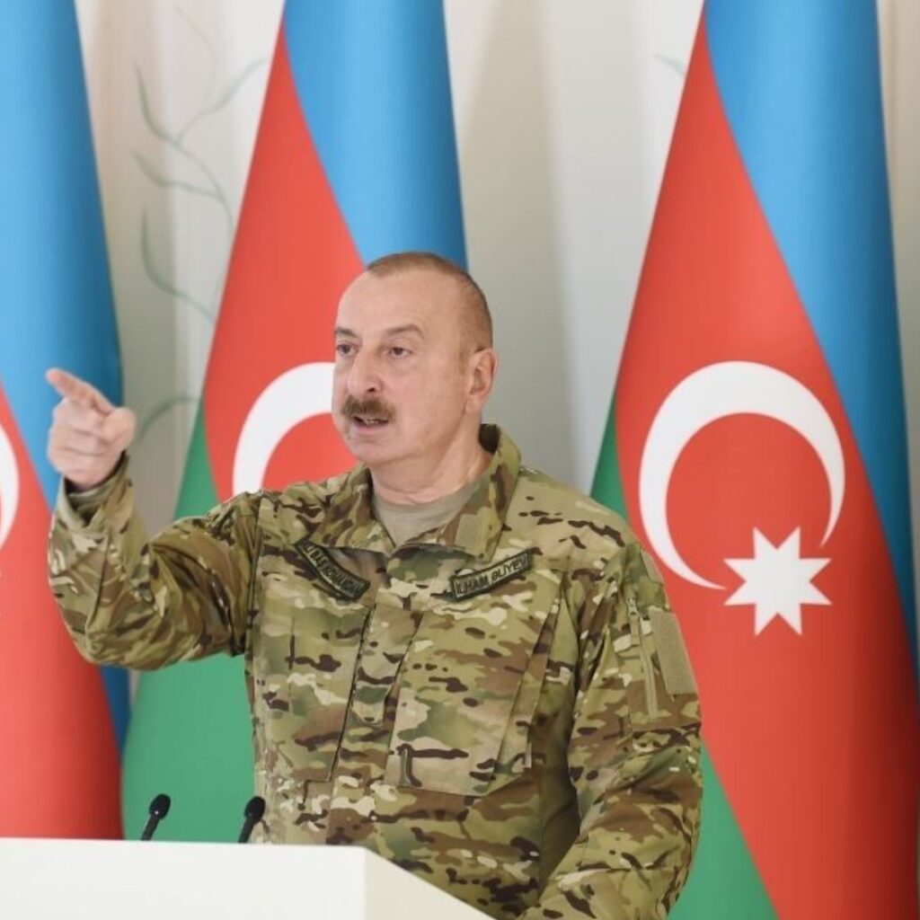 Azerbaijani President Ilham Aliyev making a fist gesture during a speech in Baku, Azerbaijan. In December 2024, Aliyev declared that Armenia is a 'fake country' that will soon disappear, escalating tensions in the South Caucasus. The statement reflects ongoing hostility between Azerbaijan and Armenia amid geopolitical disputes.