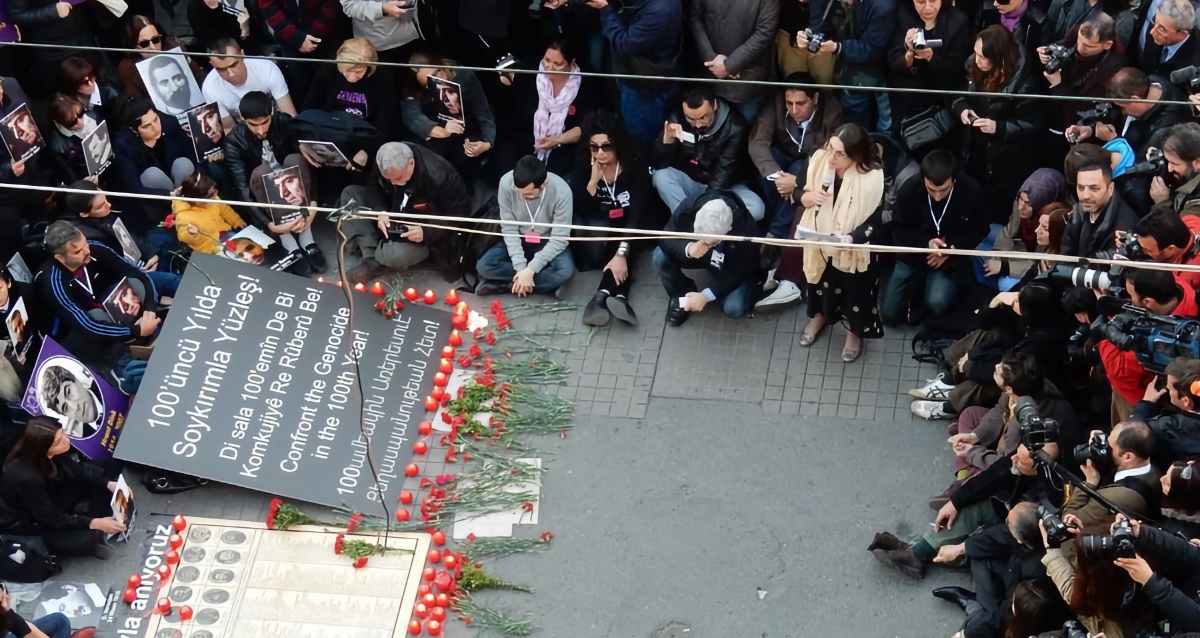 Ani Boghikian-Kasparian at the 2015 Armenian Genocide commemoration in Istanbul’s Beyoğlu, seated with hundreds around candles and posters honoring arrested Armenian intellectuals.