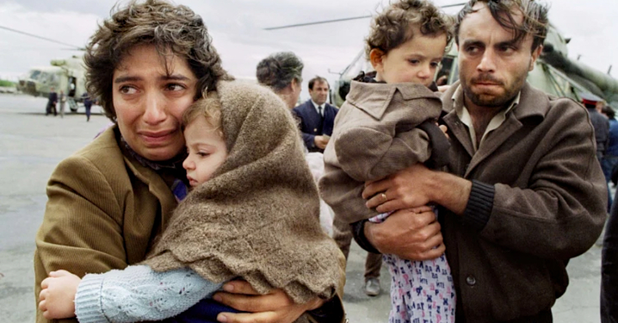 Armenian refugees from Nagorno-Karabakh carrying children after fleeing war and ethnic cleansing.